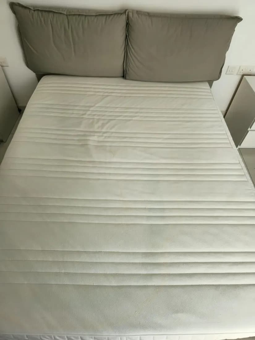 double mattress on an upholstered bed before cleaning by ARA Clean Malta